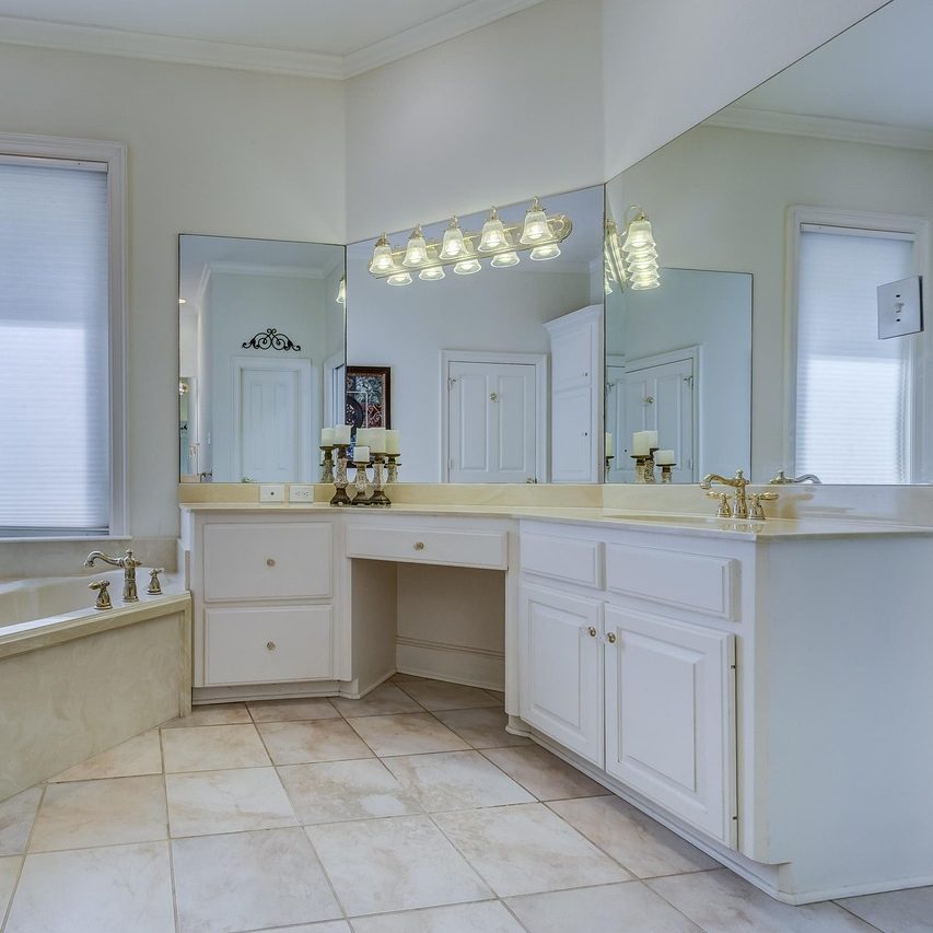 Custom frameless mirror installed above a bathroom vanity in a Jacksonville home