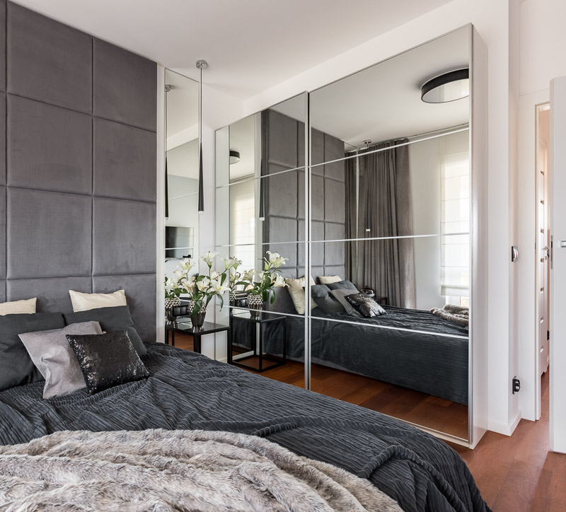 Custom mirrored closet doors and wall mirrors installed in a Jacksonville bedroom